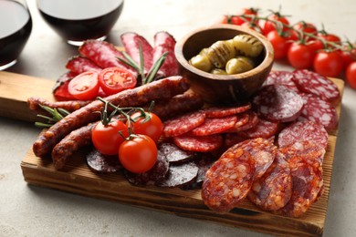 Photo of Different smoked sausages slices served on light table, closeup