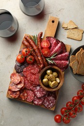 Photo of Different smoked sausages slices served on light table, flat lay