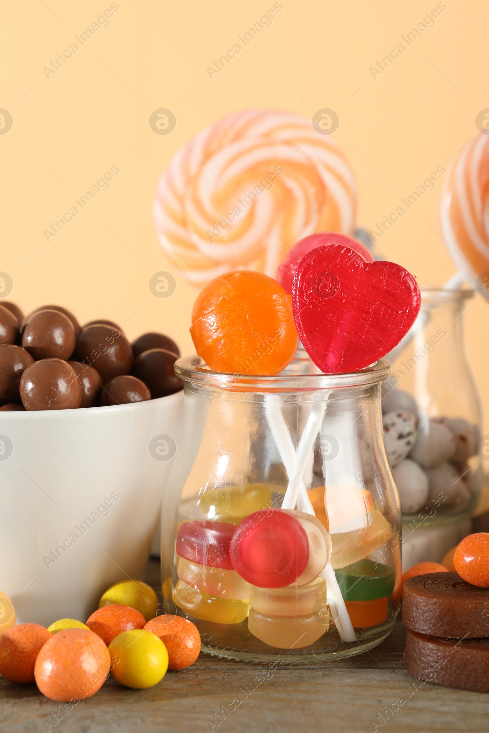 Photo of Candy bar. Many different sweets on wooden table against beige background, closeup