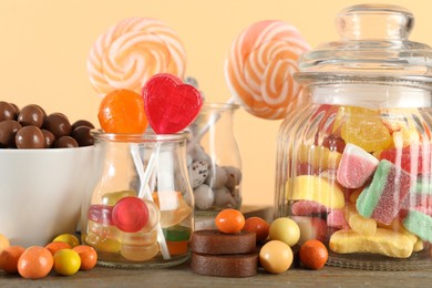 Photo of Candy bar. Many different sweets on wooden table against beige background, closeup