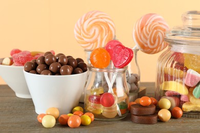 Photo of Candy bar. Many different sweets on wooden table against beige background, closeup