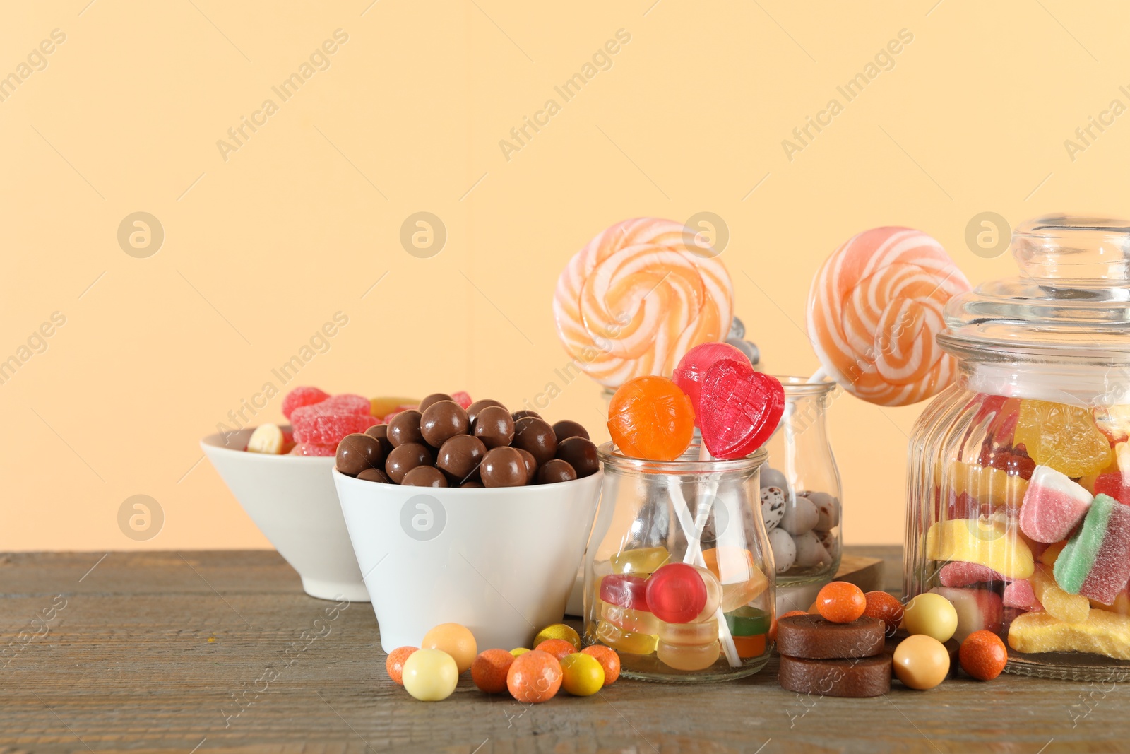 Photo of Candy bar. Many different sweets on wooden table against beige background. Space for text