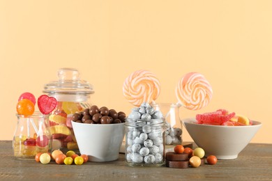 Photo of Candy bar. Many different sweets on wooden table against beige background. Space for text