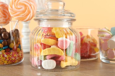 Photo of Candy bar. Many different sweets on wooden table against beige background, closeup