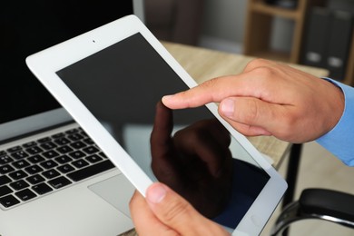 Photo of Businessman using tablet at table, closeup. Modern technology