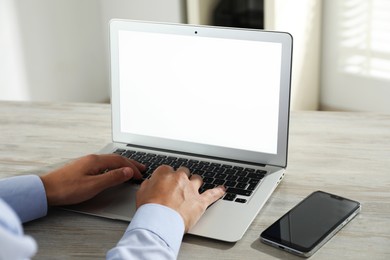 Photo of Businessman using laptop at wooden table, closeup. Modern technology