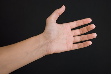 Photo of Woman with visible hand veins on black background, closeup