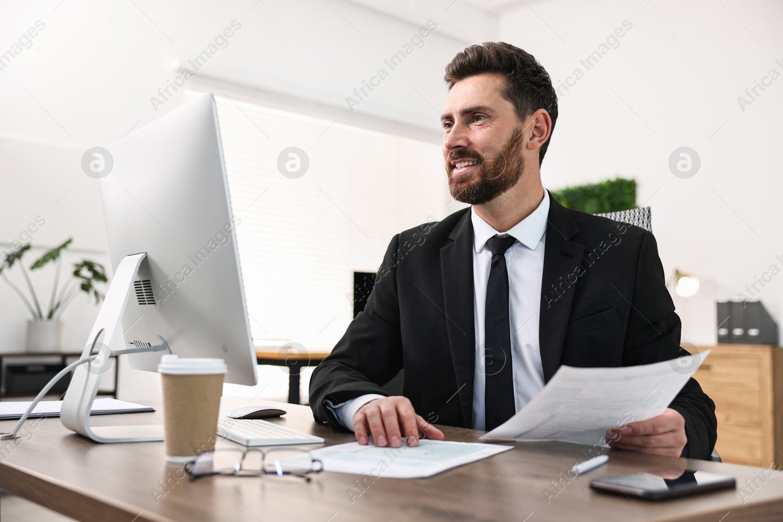 Photo of Man working with documents at table in office