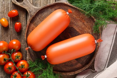 Photo of Tasty boiled sausages, tomatoes and dill on wooden table, top view