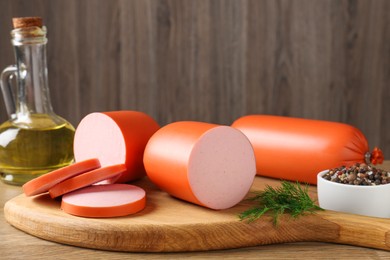 Photo of Tasty boiled sausages and spices on wooden table, closeup