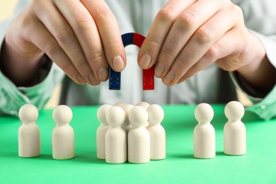 Photo of Woman with magnet attracting game pieces at green table, closeup