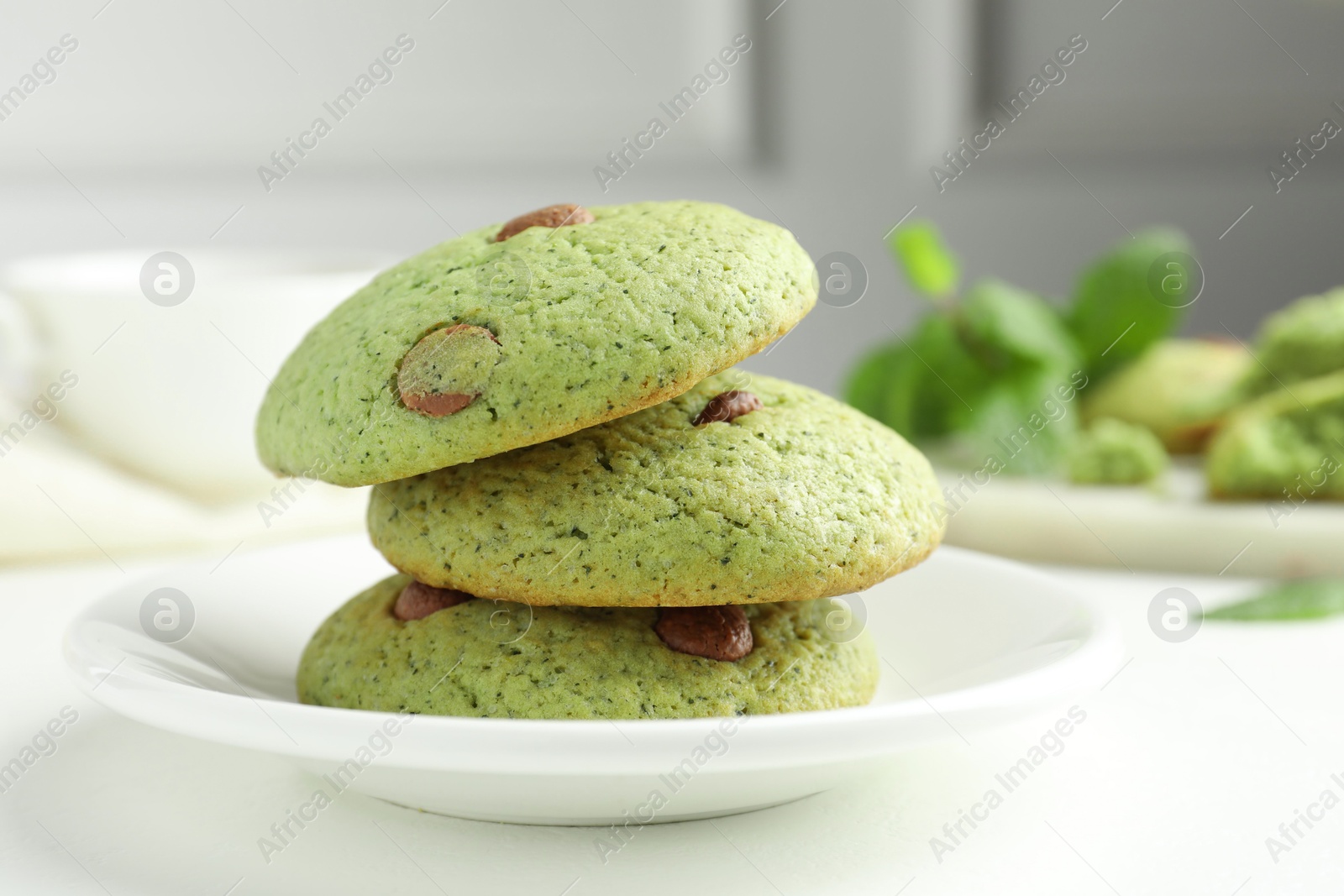 Photo of Delicious mint chocolate chip cookies on white table, closeup