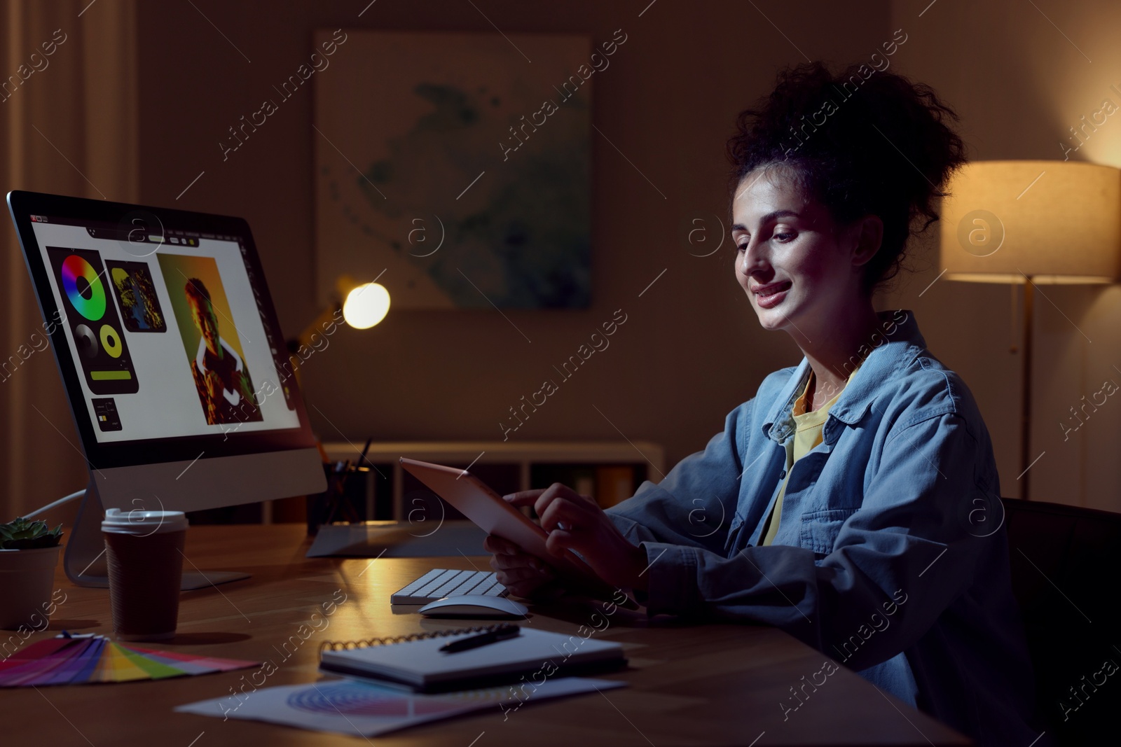 Photo of Designer working on tablet indoors at night