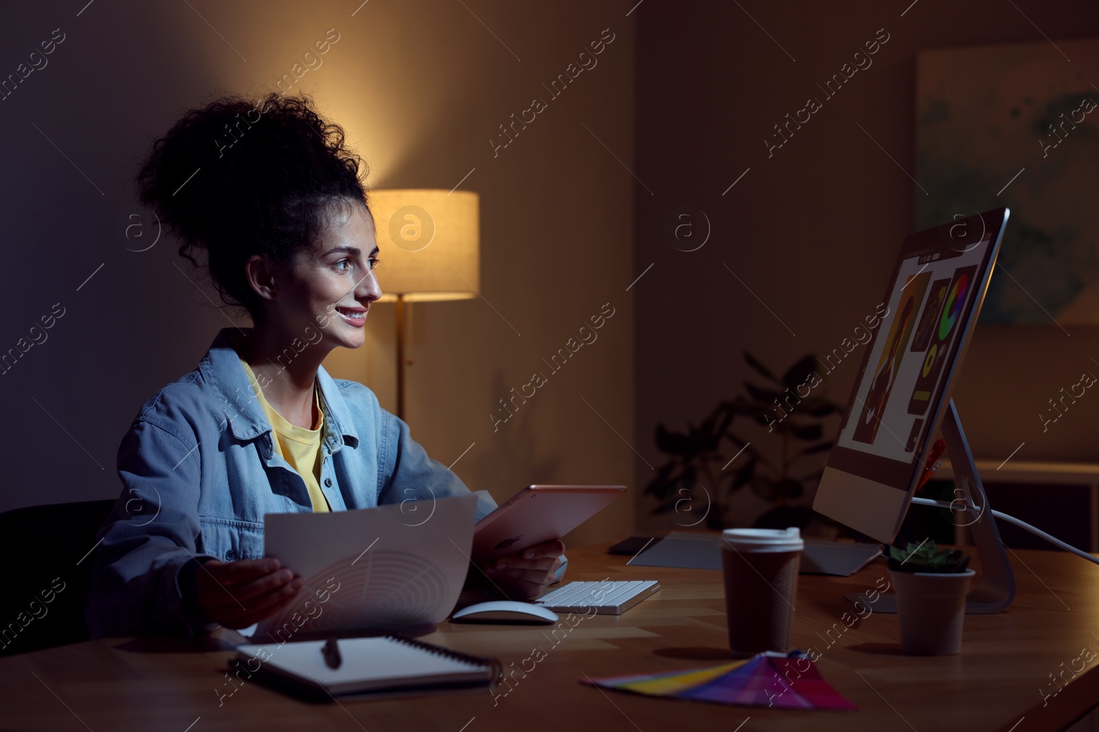 Photo of Designer with tablet and color palette working indoors at night