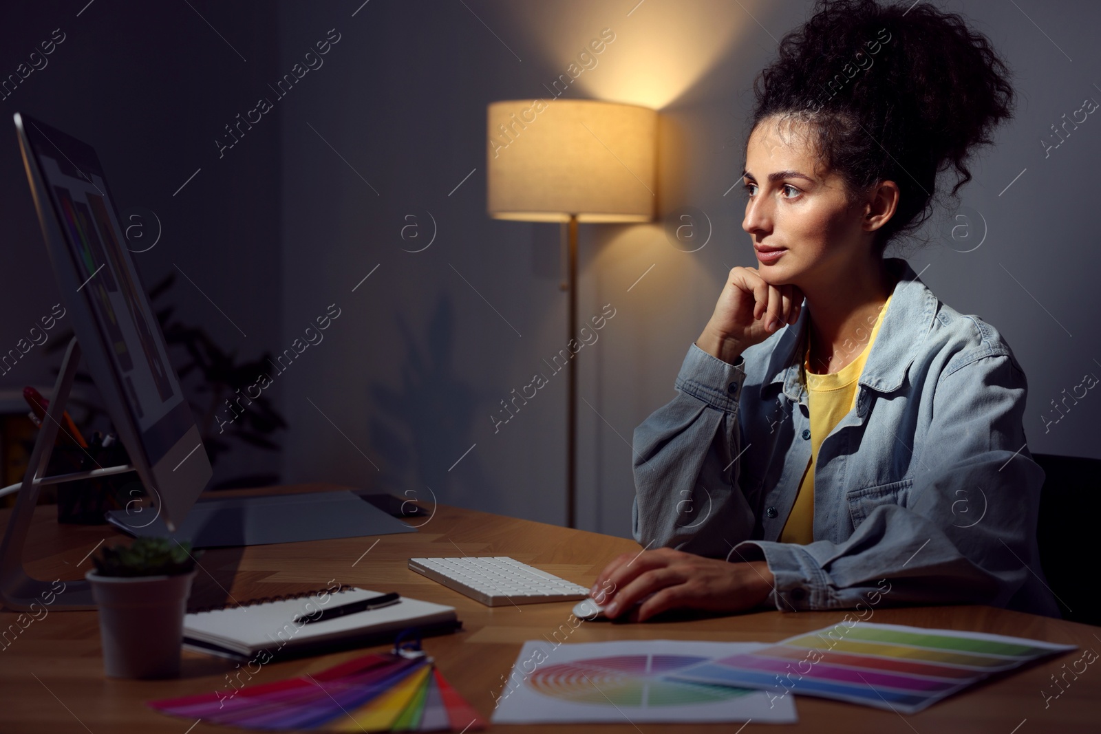 Photo of Designer working on computer indoors at night