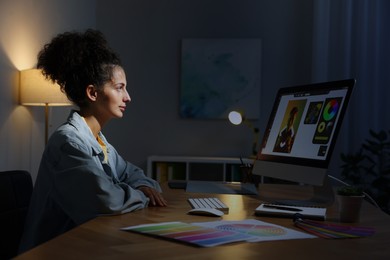 Photo of Designer working on computer indoors at night