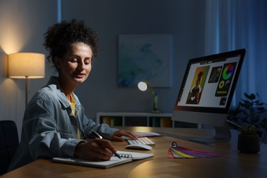 Photo of Designer with notebook working indoors at night