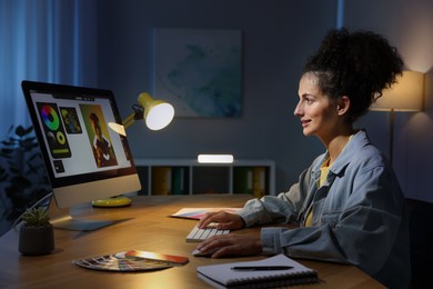 Photo of Designer working on computer indoors at night