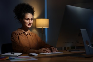 Photo of Designer working on computer indoors at night