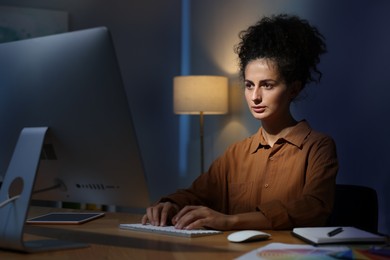 Photo of Designer working on computer indoors at night