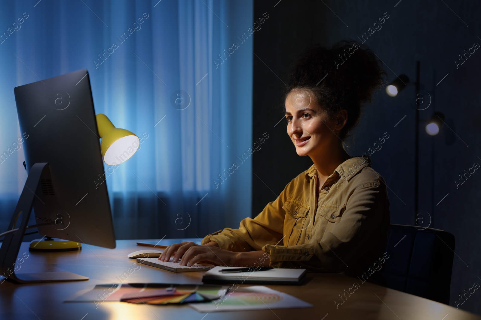 Photo of Designer working on computer indoors at night