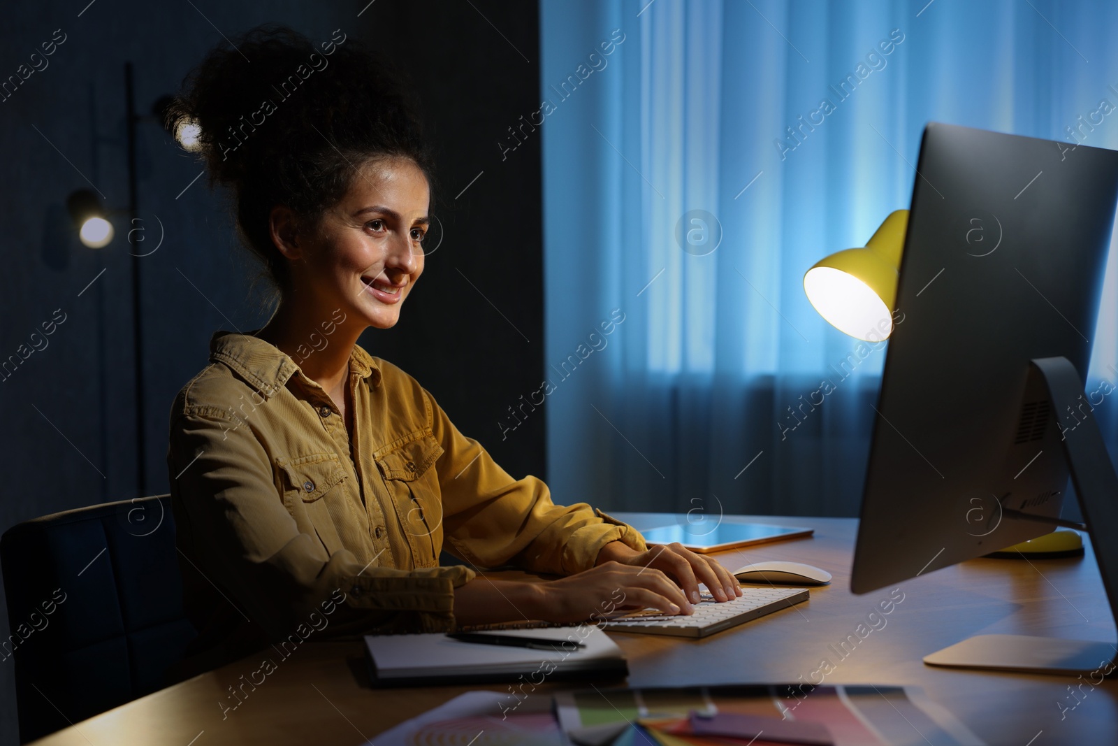 Photo of Designer working on computer indoors at night