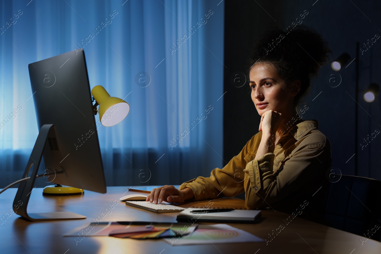 Photo of Designer working on computer indoors at night