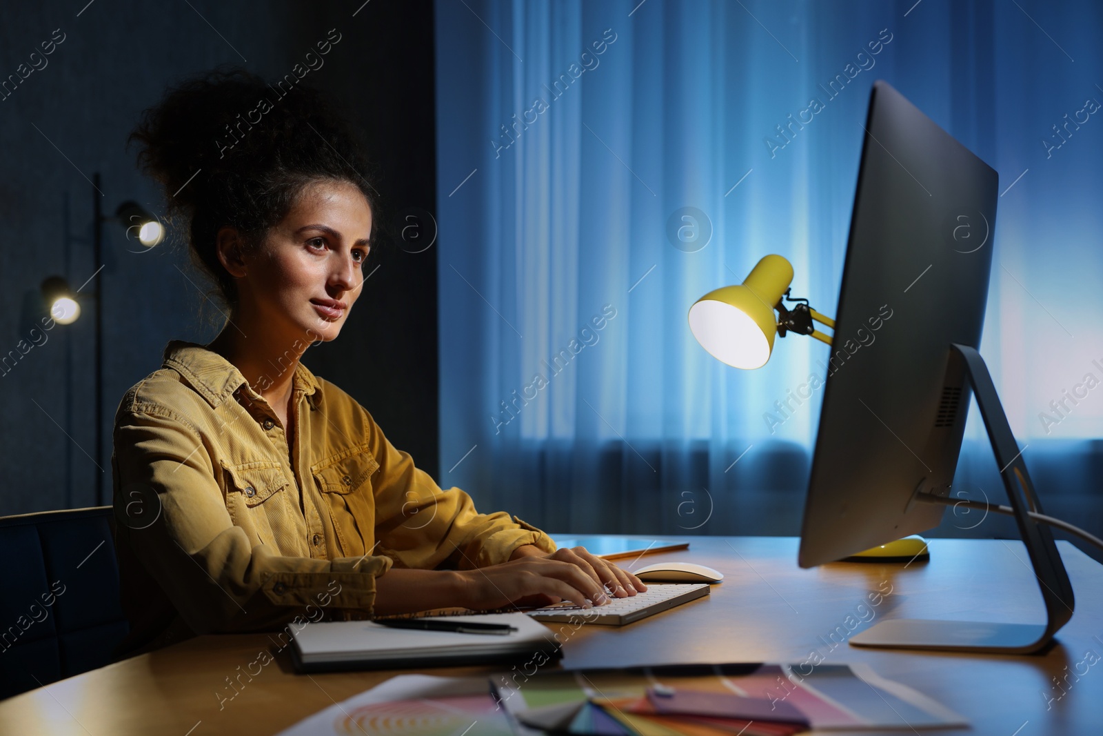 Photo of Designer working on computer indoors at night