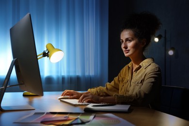 Photo of Designer working on computer indoors at night