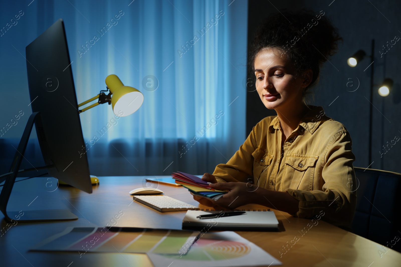 Photo of Designer with color palette working indoors at night