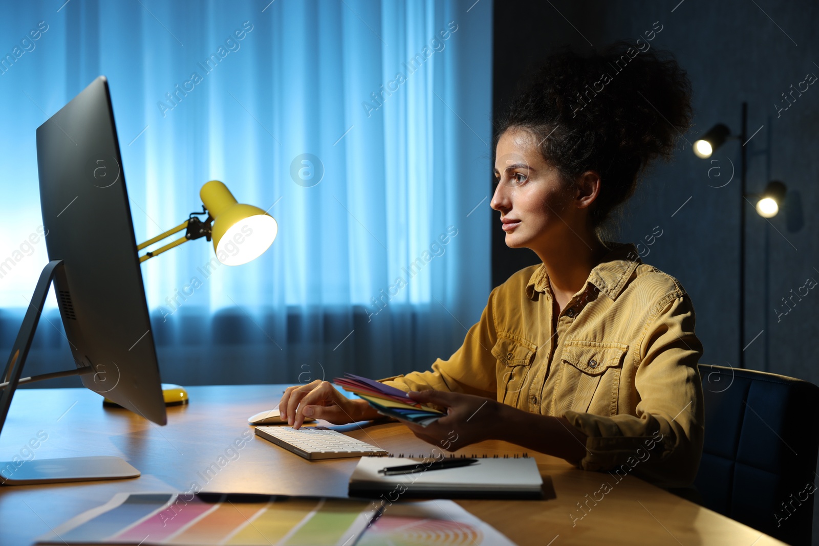 Photo of Designer with color palette working indoors at night