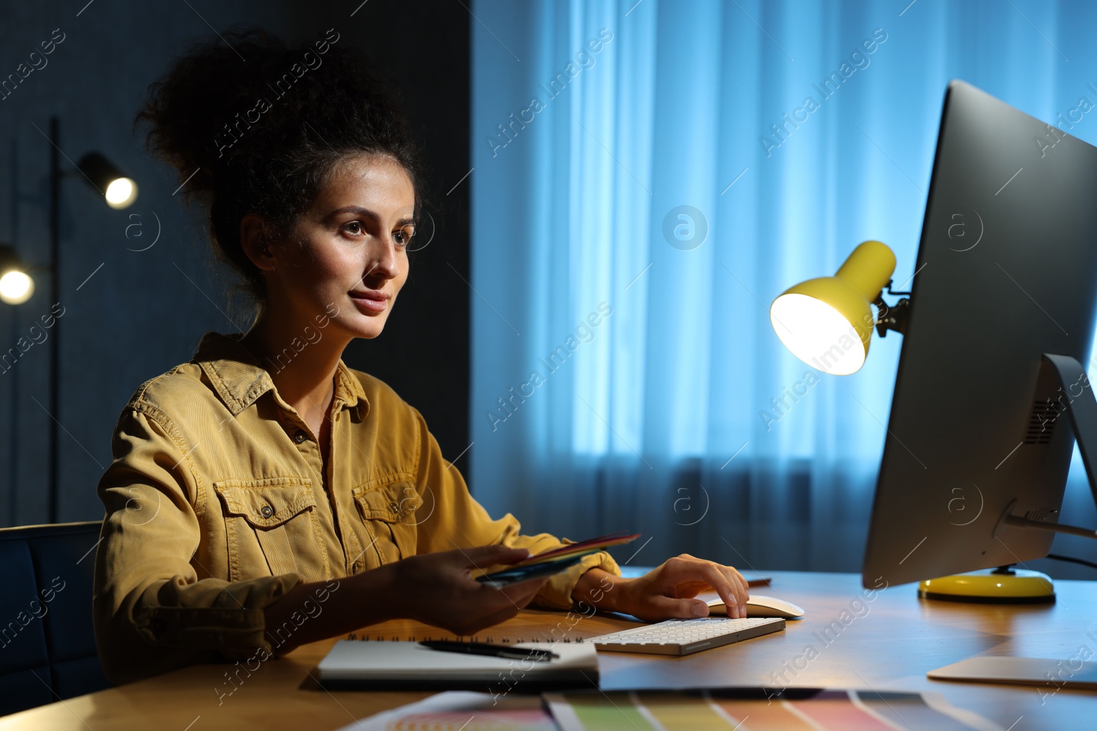 Photo of Designer with color palette working indoors at night