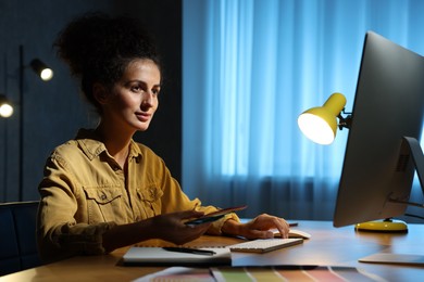 Photo of Designer with color palette working indoors at night