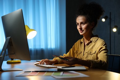 Designer with color palette working indoors at night