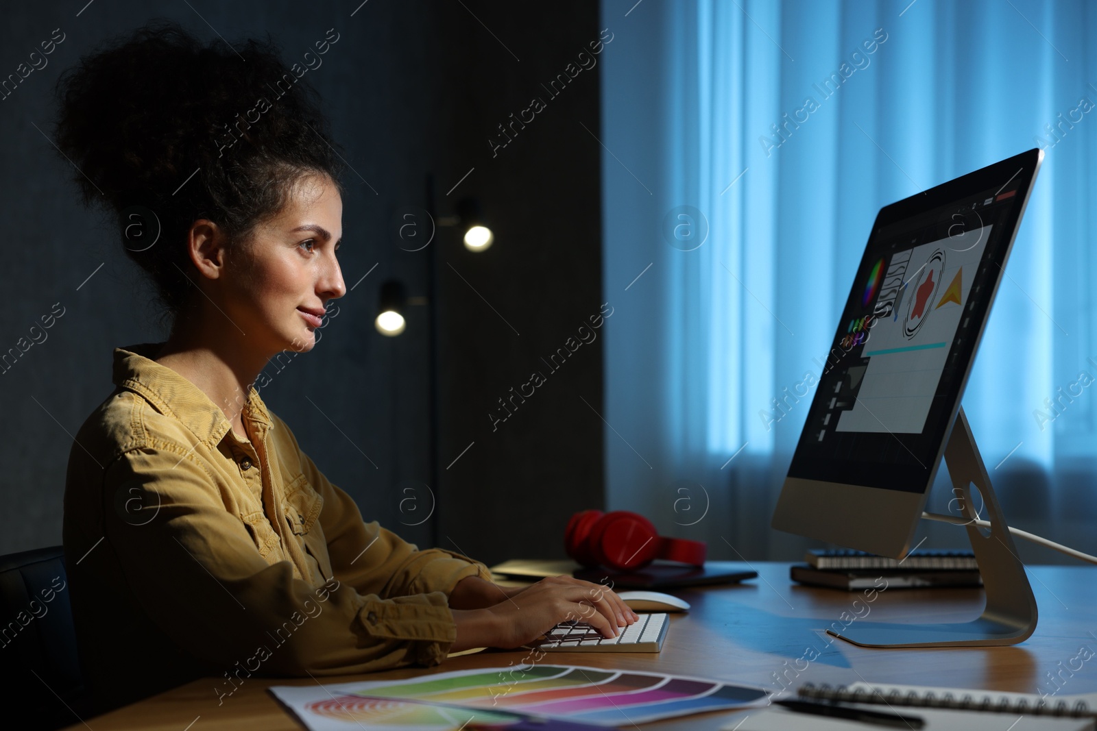 Photo of Designer working on computer indoors at night