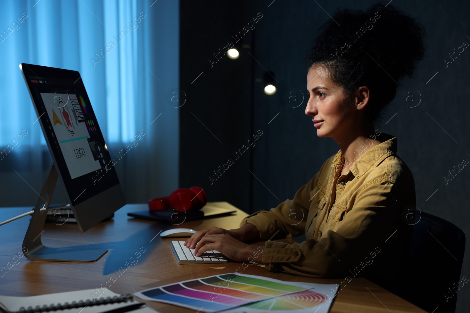 Photo of Designer working on computer indoors at night