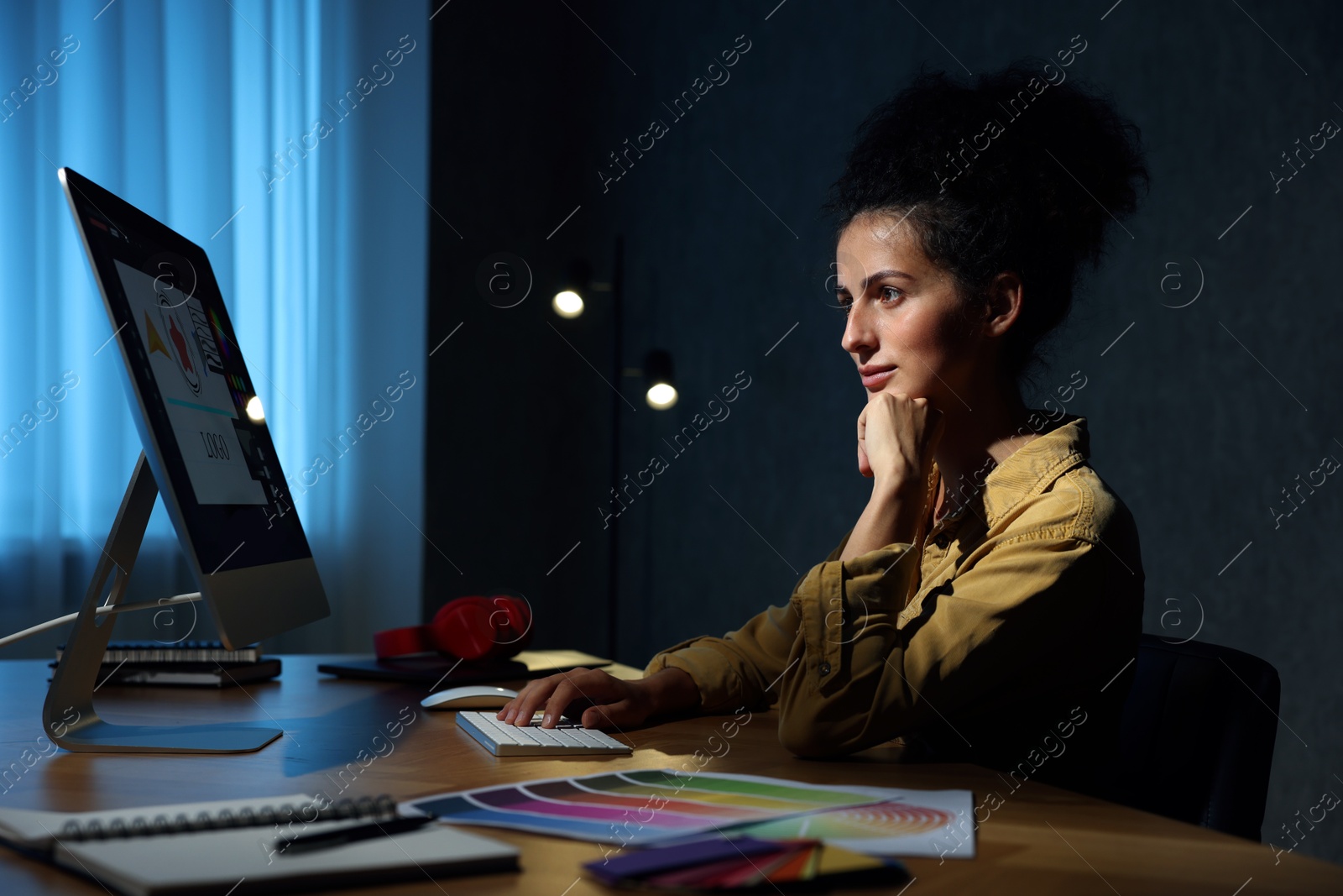 Photo of Designer working on computer indoors at night