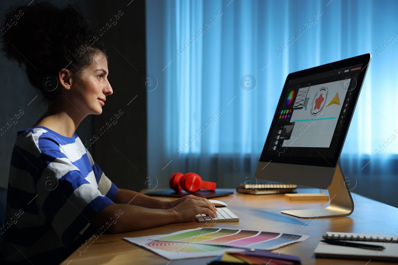 Photo of Designer working on computer indoors at night