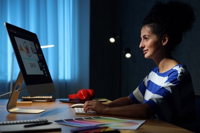 Photo of Designer working on computer indoors at night