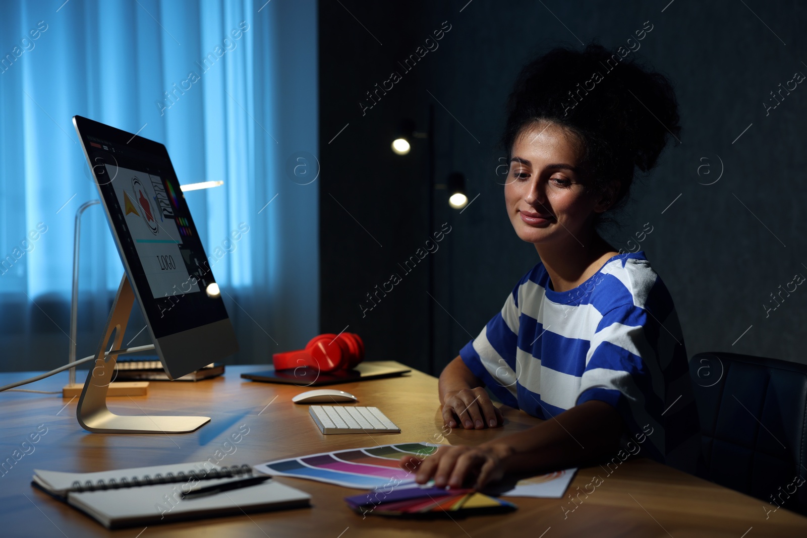 Photo of Designer with color palette working indoors at night