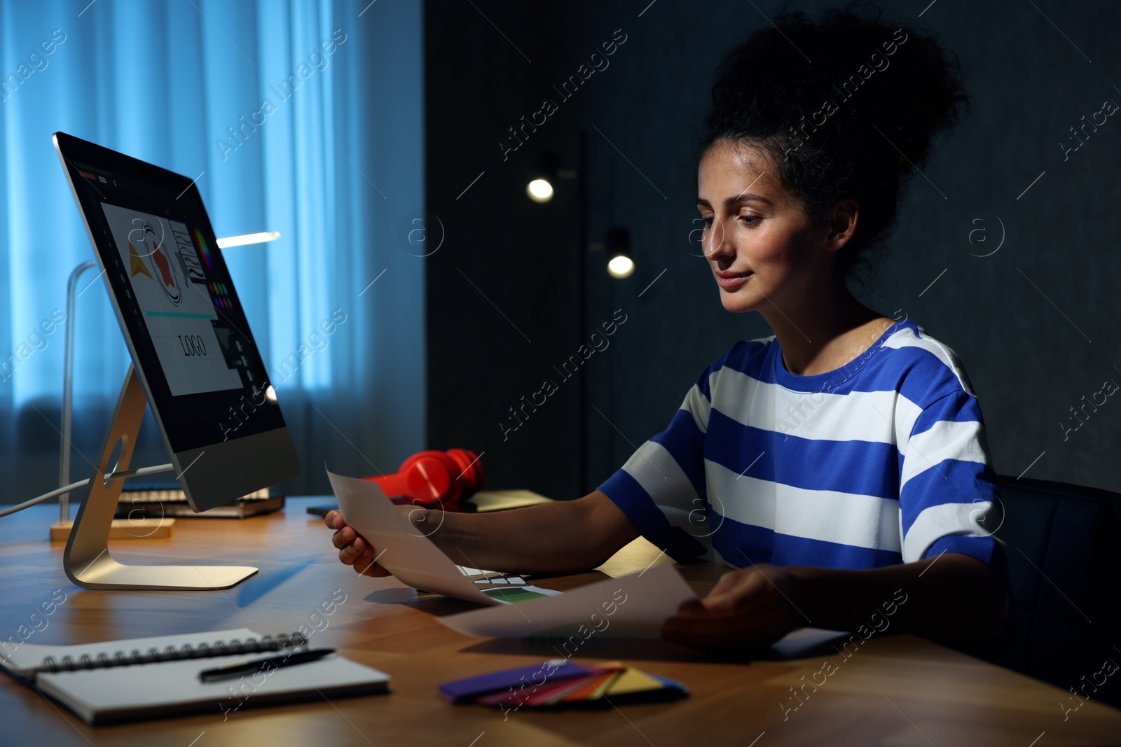 Photo of Designer with color palette working indoors at night