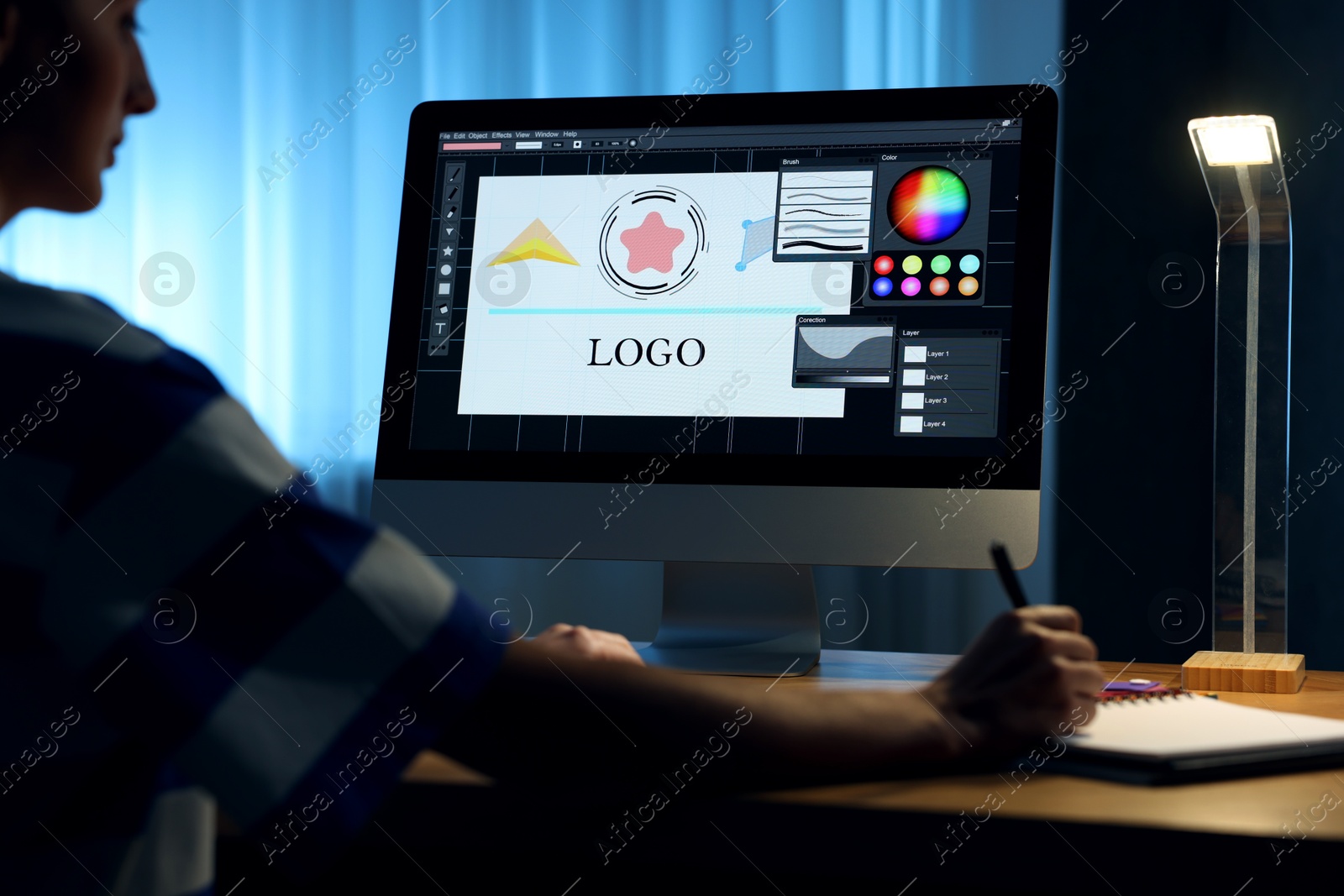 Photo of Designer working on computer indoors at night, closeup