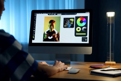 Photo of Designer working on computer indoors at night, closeup