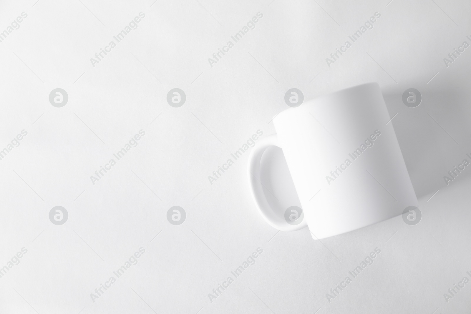 Photo of One blank mug on white background, top view. Mockup for design