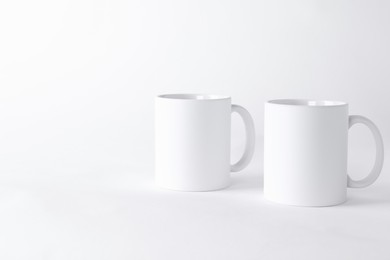 Photo of Two blank mugs on white background. Mockup for design