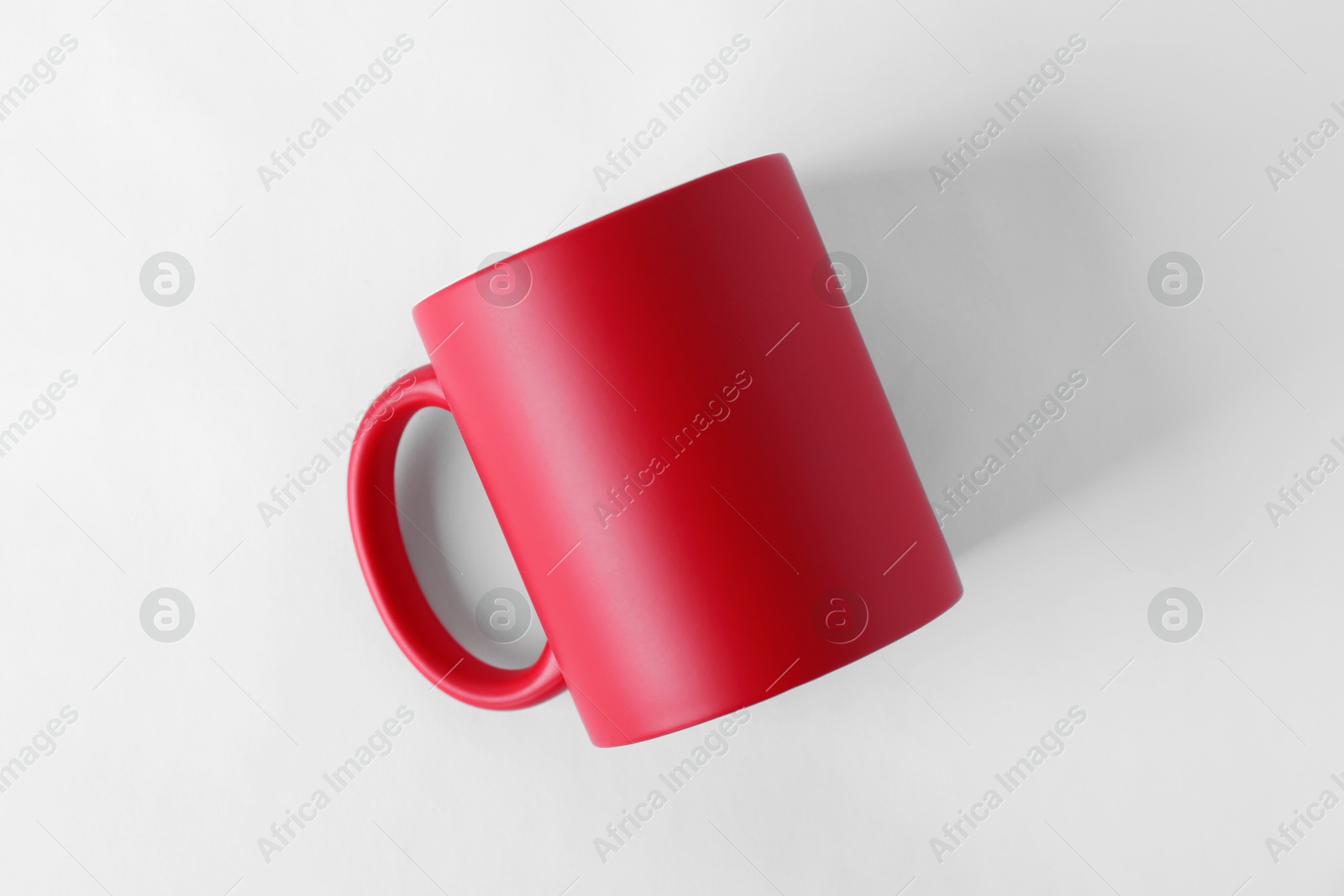 Photo of One blank red mug on white background, top view. Mockup for design