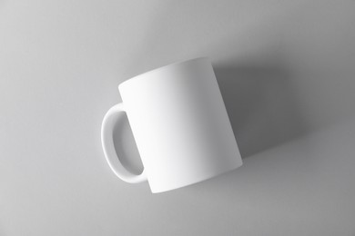 Photo of One blank white mug on light background, top view. Mockup for design