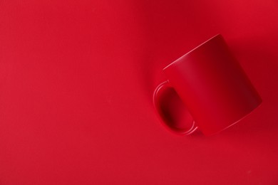 Photo of One blank mug on red background, top view. Mockup for design