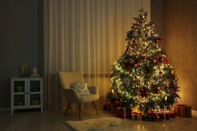 Photo of Cozy room with beautiful Christmas tree and armchair. Festive interior design