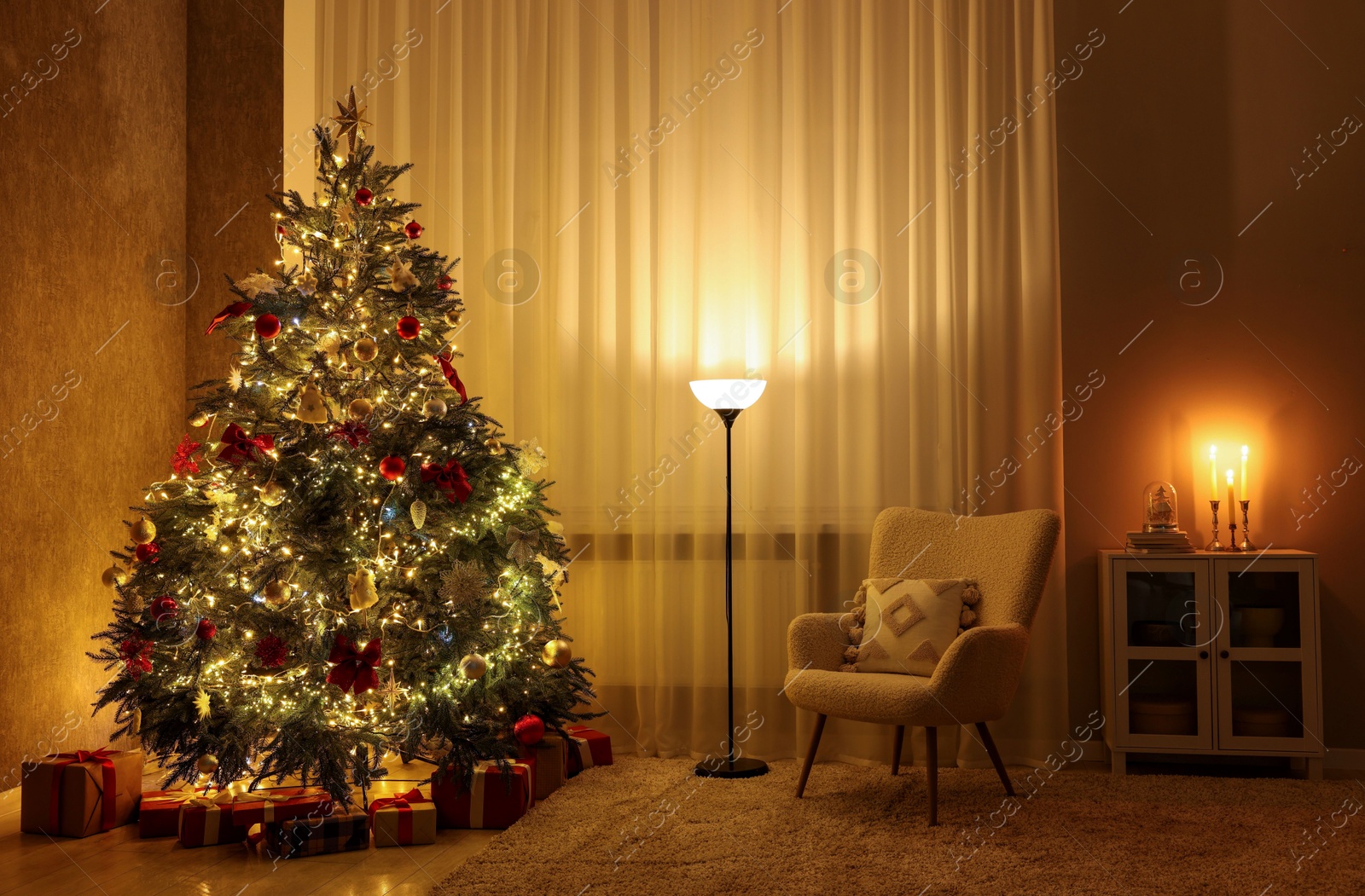 Photo of Cozy room with beautiful Christmas tree, armchair and lamp. Interior design for holiday